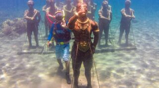 Wisatawan menyelam di dekat patung bawah laut Majapahit's Warrior Underwater