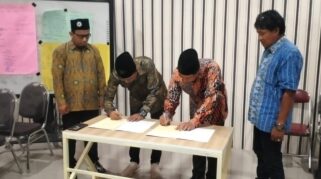 Direktur Utama PT Syarikat Cahaya Media dan Kepala SMK Models berjabat tangan setelah penandatanganan MoU.
