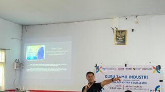 Foto menunjukkan seorang instruktur sedang menjelaskan materi fiber optik di depan para siswa di SMK Models.