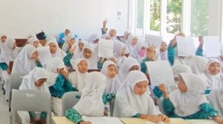 Siswi MI Darunnajah II antusias menulis surat kepada Bupati Banyuwangi dalam kegiatan literasi madrasah.