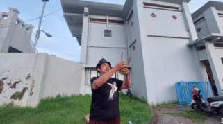 KRT Ilham Triadi Nagoro, pawang hujan, sedang melakukan ritual di dekat Stadion Diponegoro Banyuwangi.