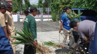 Mahasiswa KKN UNAIR membantu warga Desa Purwoagung mencacah rumput untuk pakan ternak.