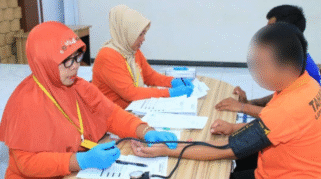 Petugas kesehatan mengambil sampel darah warga binaan selama tes HIV