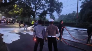 petugas dari Dinas Damkarmat Banyuwangi membersihkan material supaya jalan kembali aman dilalui